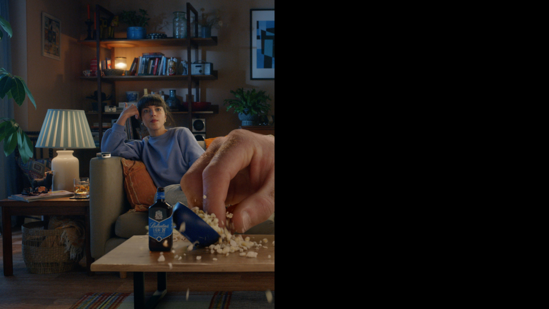 Girl staying in at home with giant hand reaching for popcorn in "half an ad" for Ballantine's Light by CPB London