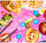 Busy image with mix of food and candy on a pink table
